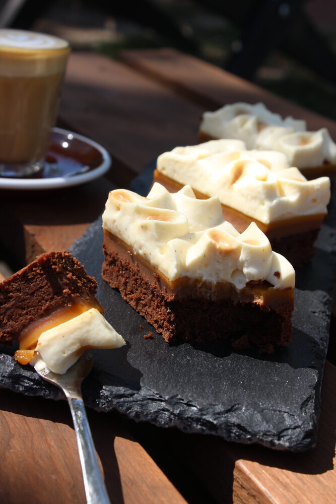 Karamellás sajttorta szeletek és cappuccino a napon